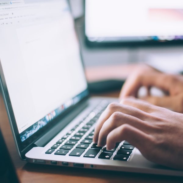 osoba pisząca na laptopie korzystająca z aplikacji do rezerwacji wizyt