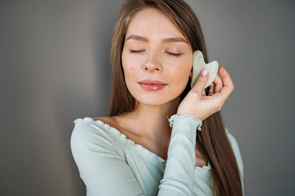 kobieta wykonująca masaż kamieniem guasha