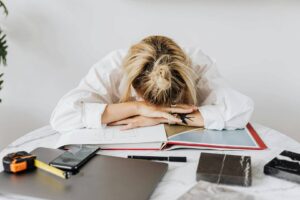 ALT: Kobieta przysypia na biurku przy pracy