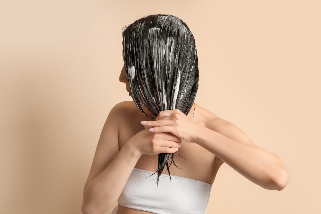 kobieta nakładająca nawilżającą maskę do włosów