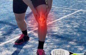 mężczyzna trzymający się za udo w wyniku kontuzji