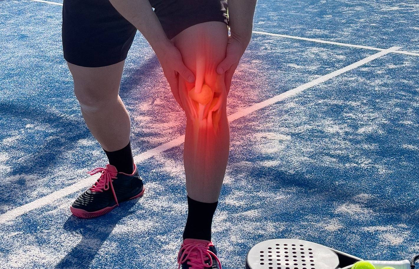 mężczyzna trzymający się za udo w wyniku kontuzji