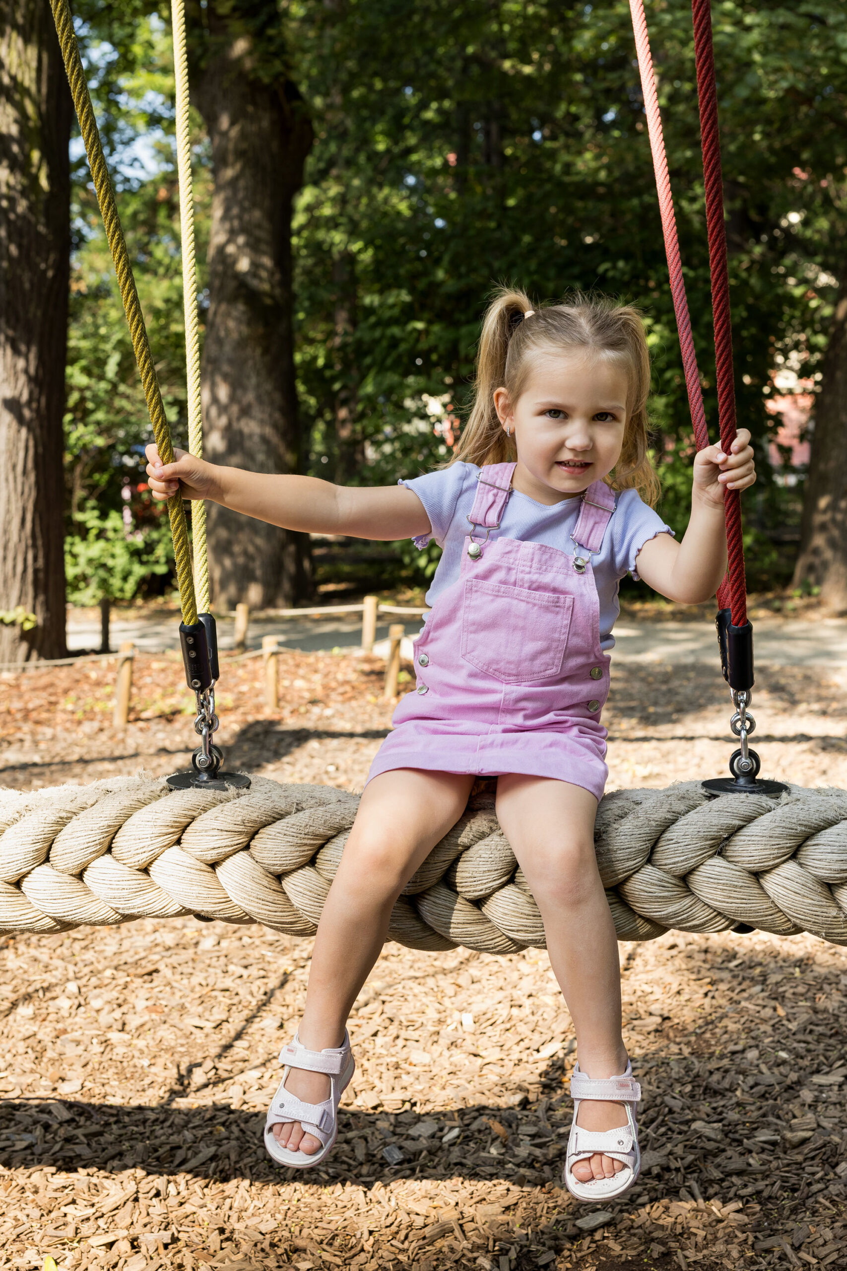 dziewczynka siedząca na huśtawce w wygodnych sandałach