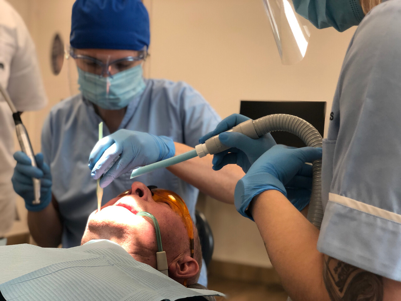 dentysta podczas zabiegu nakładania licówek