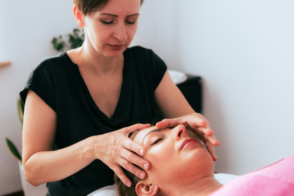 Masaż twarzy wykonywany przez terapeutkę w gabinecie kosmetycznym