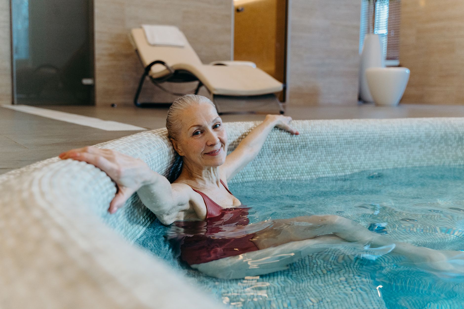 Seniorka relaksująca się w basenie spa na stawy