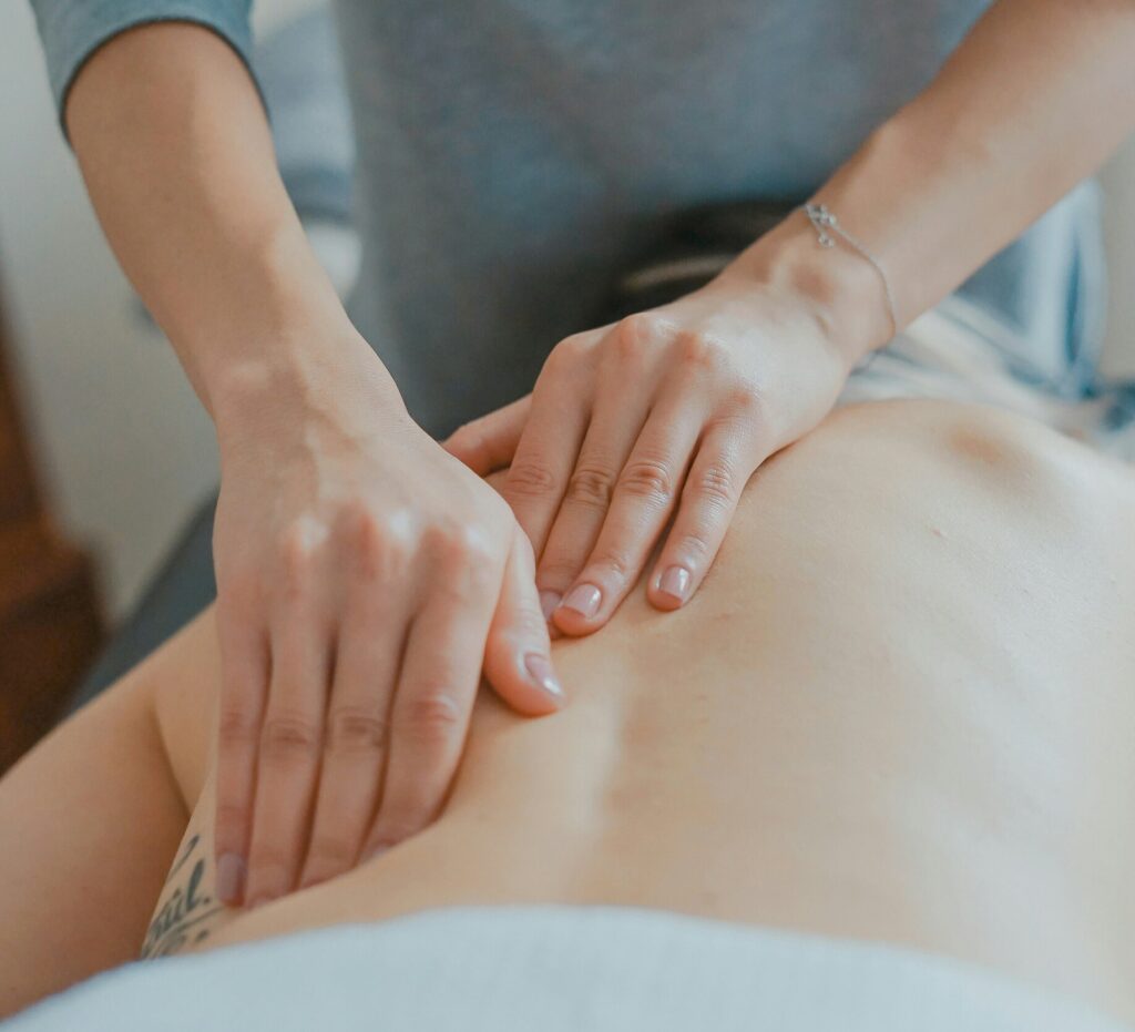 terapeuta podczas wykonywania terapii czaszkowo-krzyżowej u pacjenta